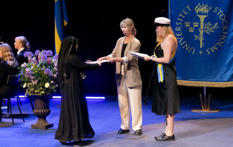 Student tilldelas sitt examensbevis vid magisterpromotionen i maj 2024.